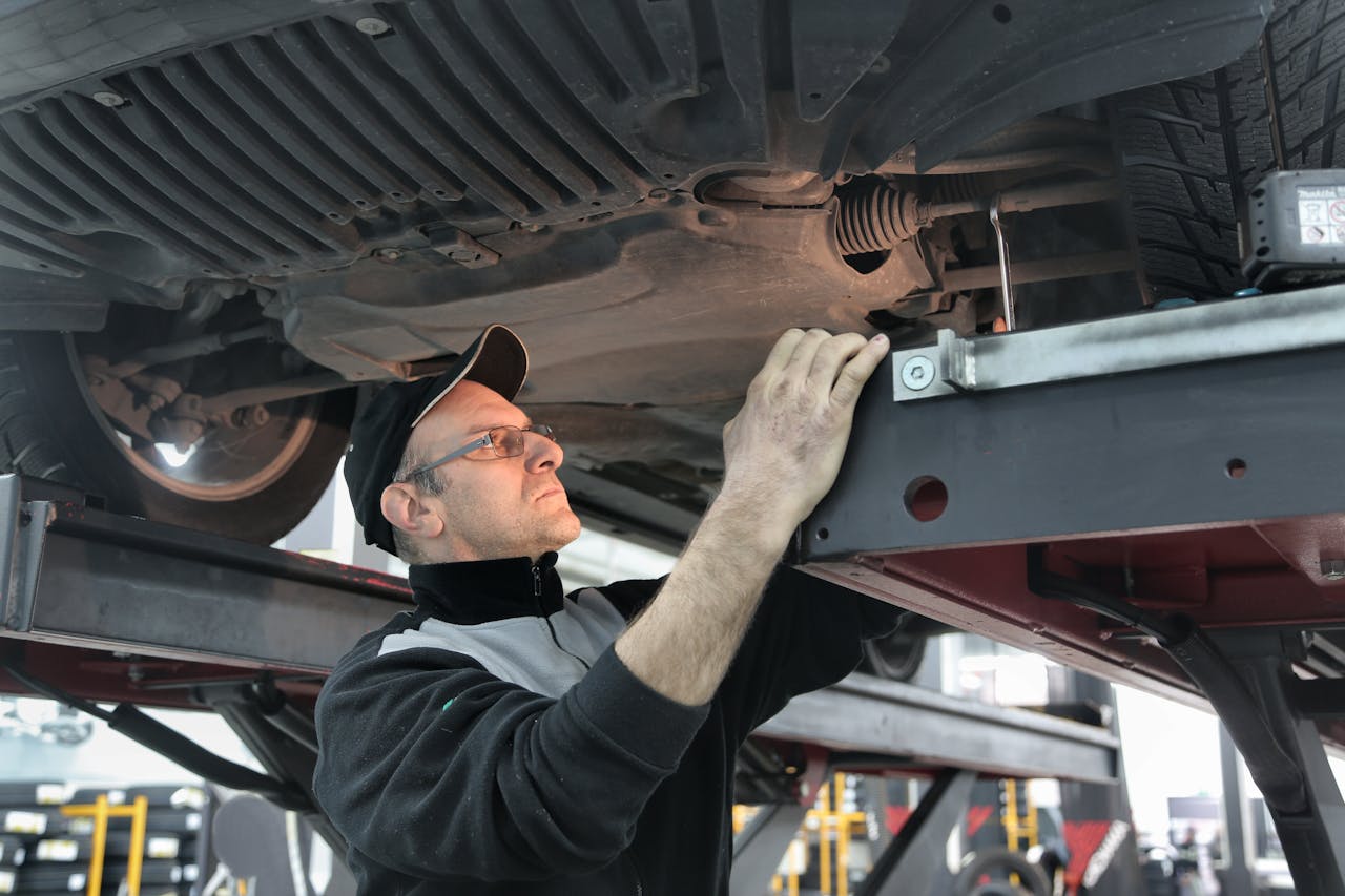 A mechanic studying the wheel of a car.