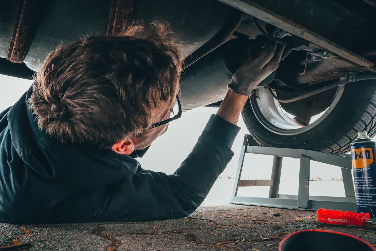 A mechanic working underneath a vehicle.