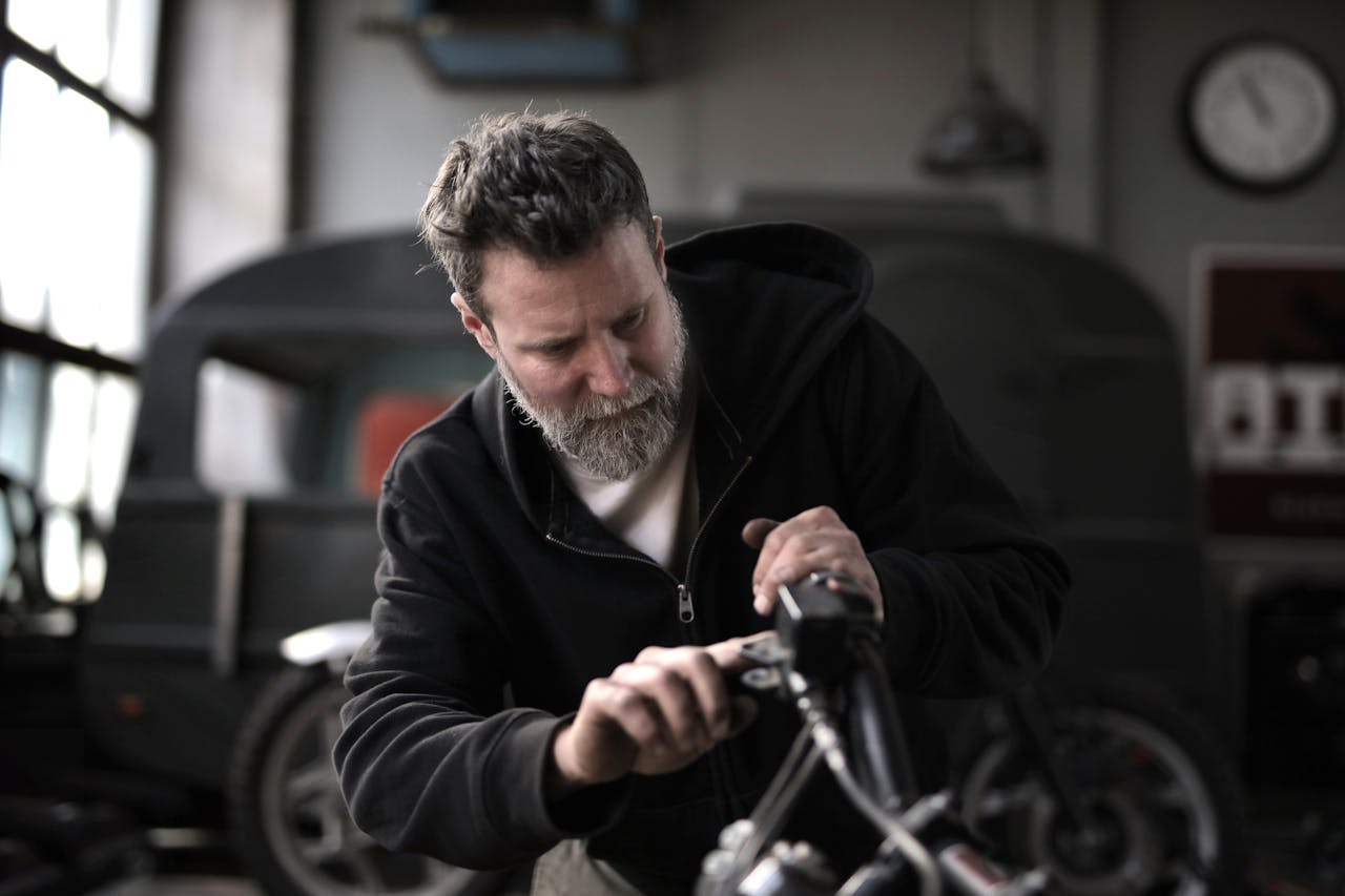 A mechanic working with tools in a garage.