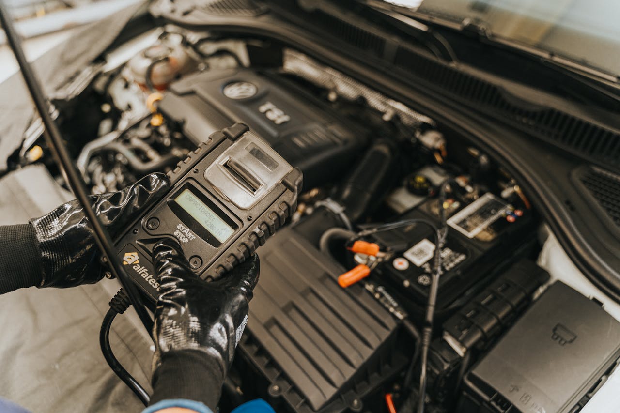 Technician using advanced diagnostic tool on engine compartment