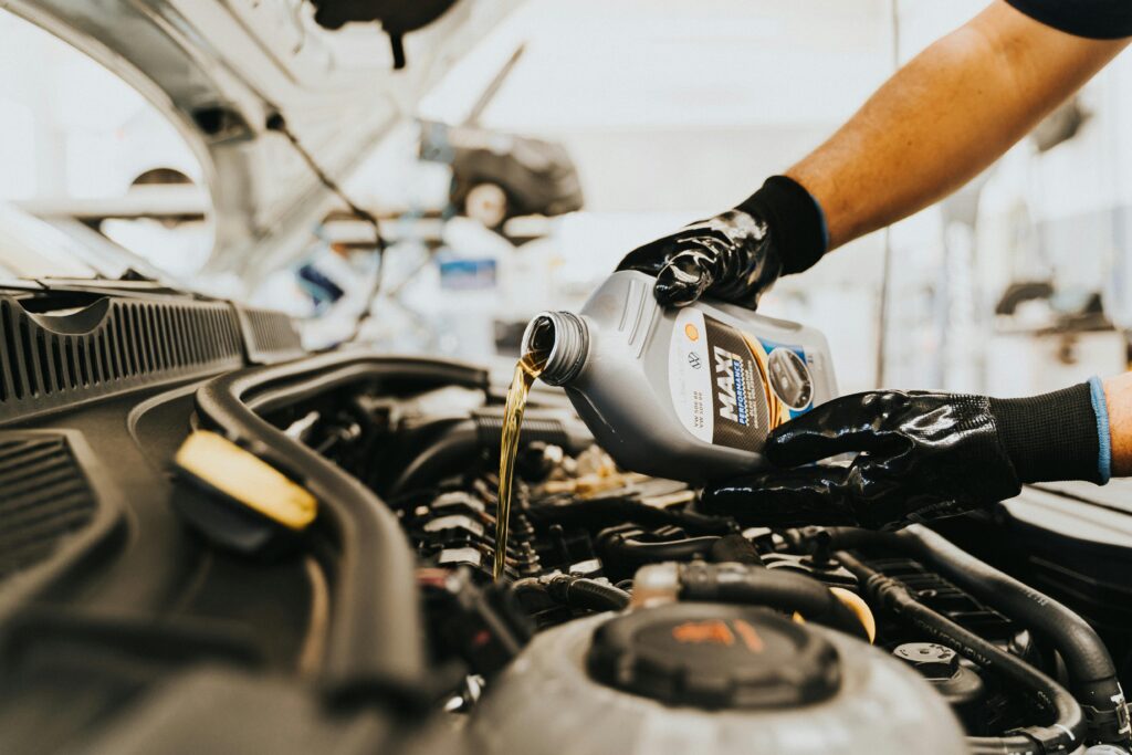 Mechanic adding OEM approved oil to engine
